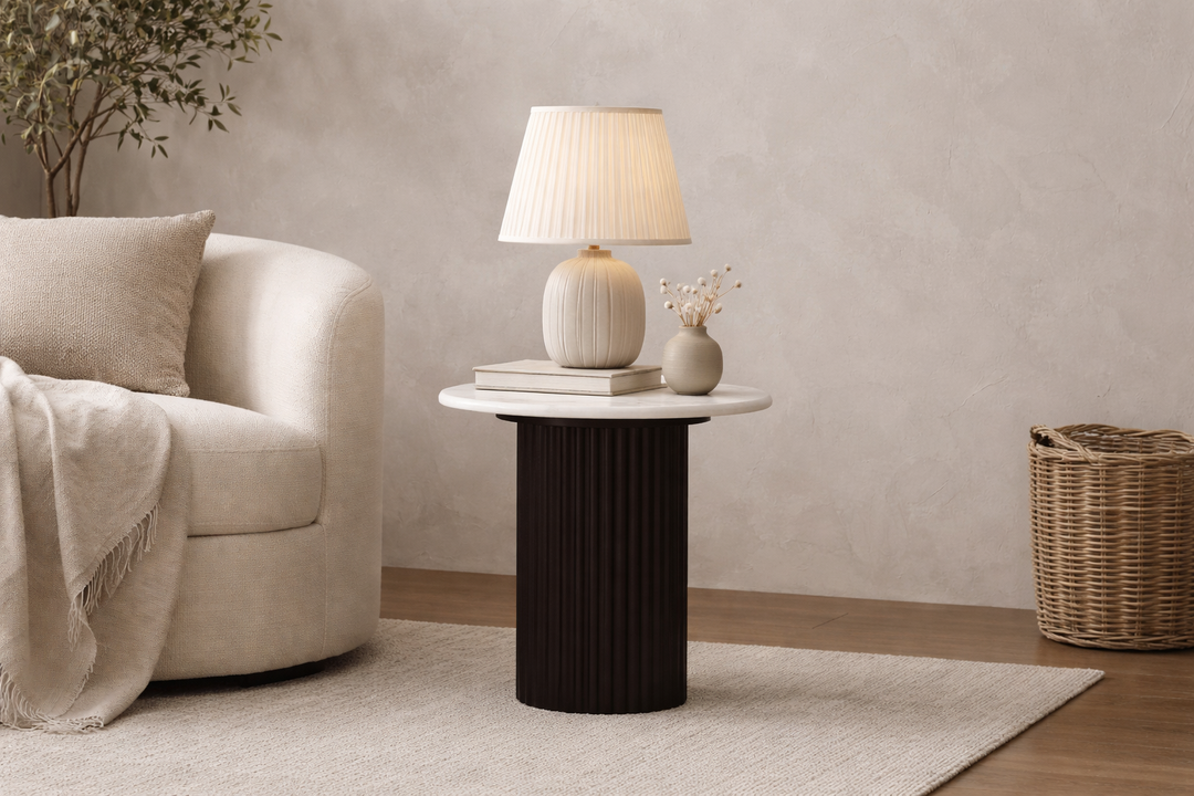 Black and white Aubrey Lamp Table from Gatsby Living in with a beige armchair, side table with a lamp, and decorative items.